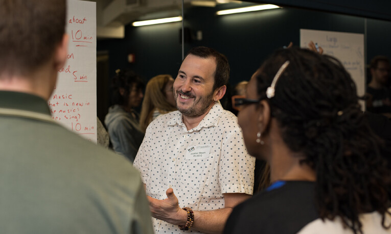 A music teacher smiles as he works with a team during a teacher training workshop.
